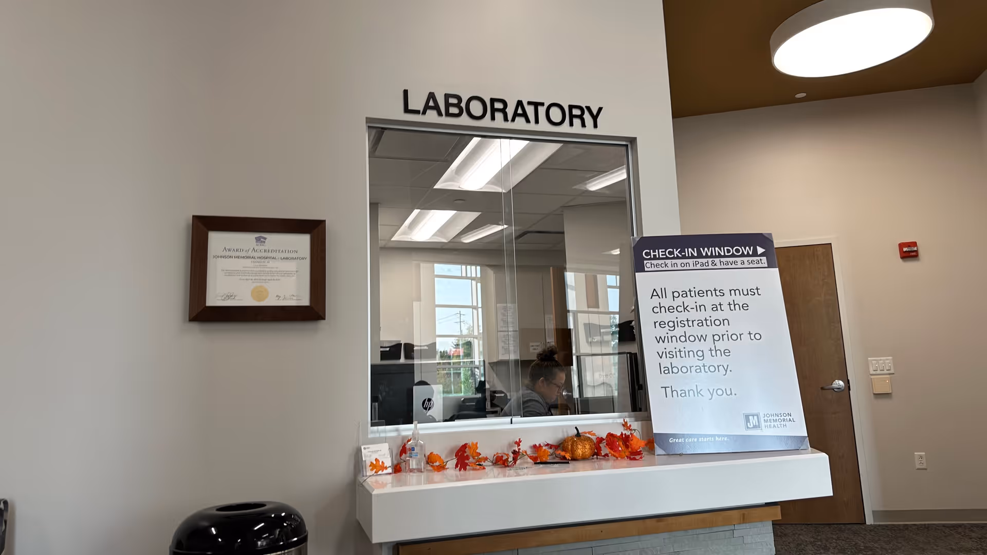 Laboratory check-in window at Johnson Memorial Health with autumn decor and staff inside.