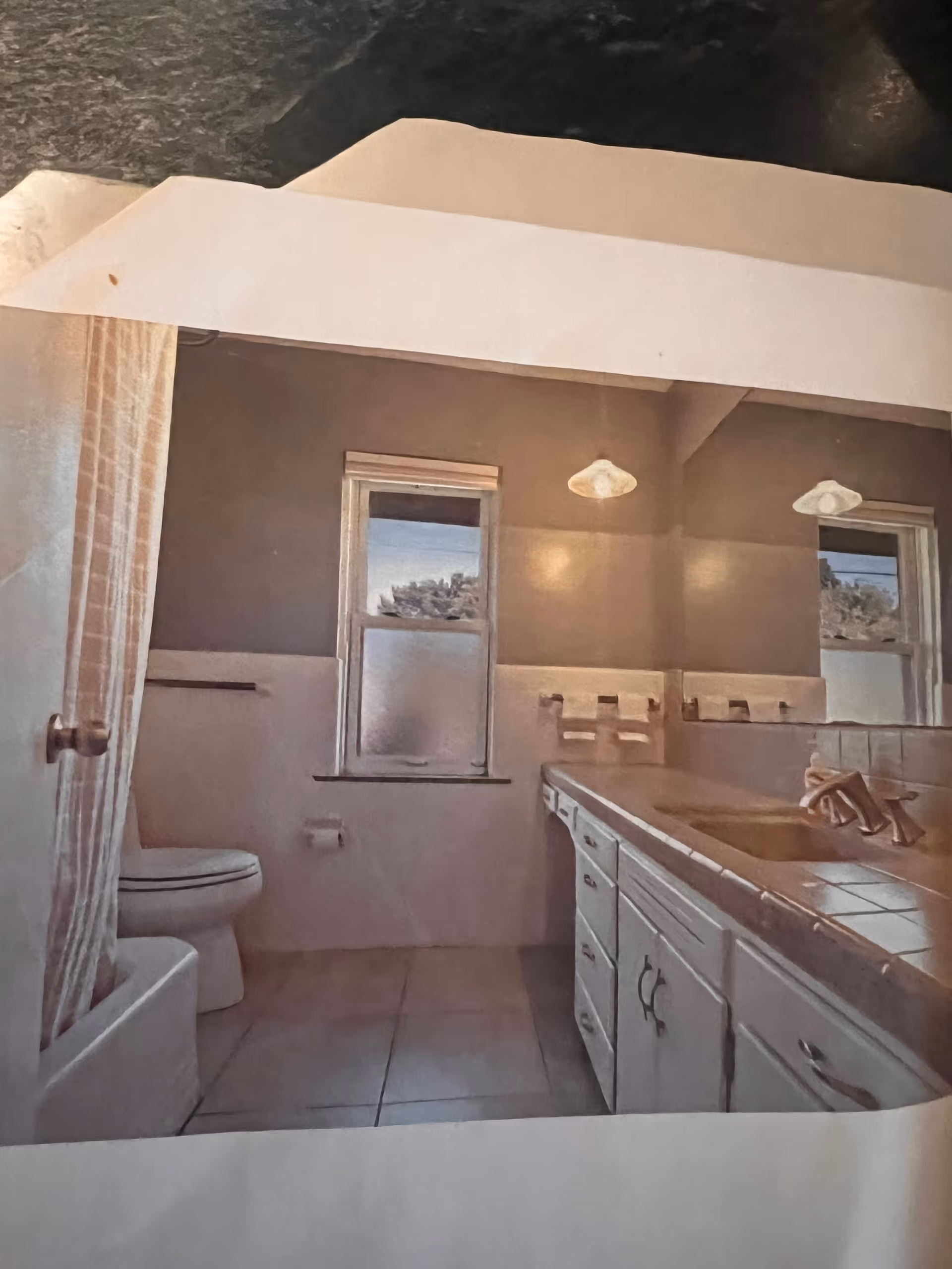 Old-fashioned bathroom with tub/shower, toilet, sink, and cabinets.