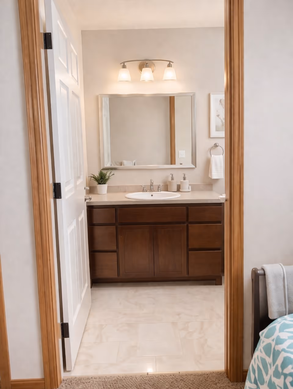 View of a bathroom vanity with a mirror, sink, and wooden cabinets.