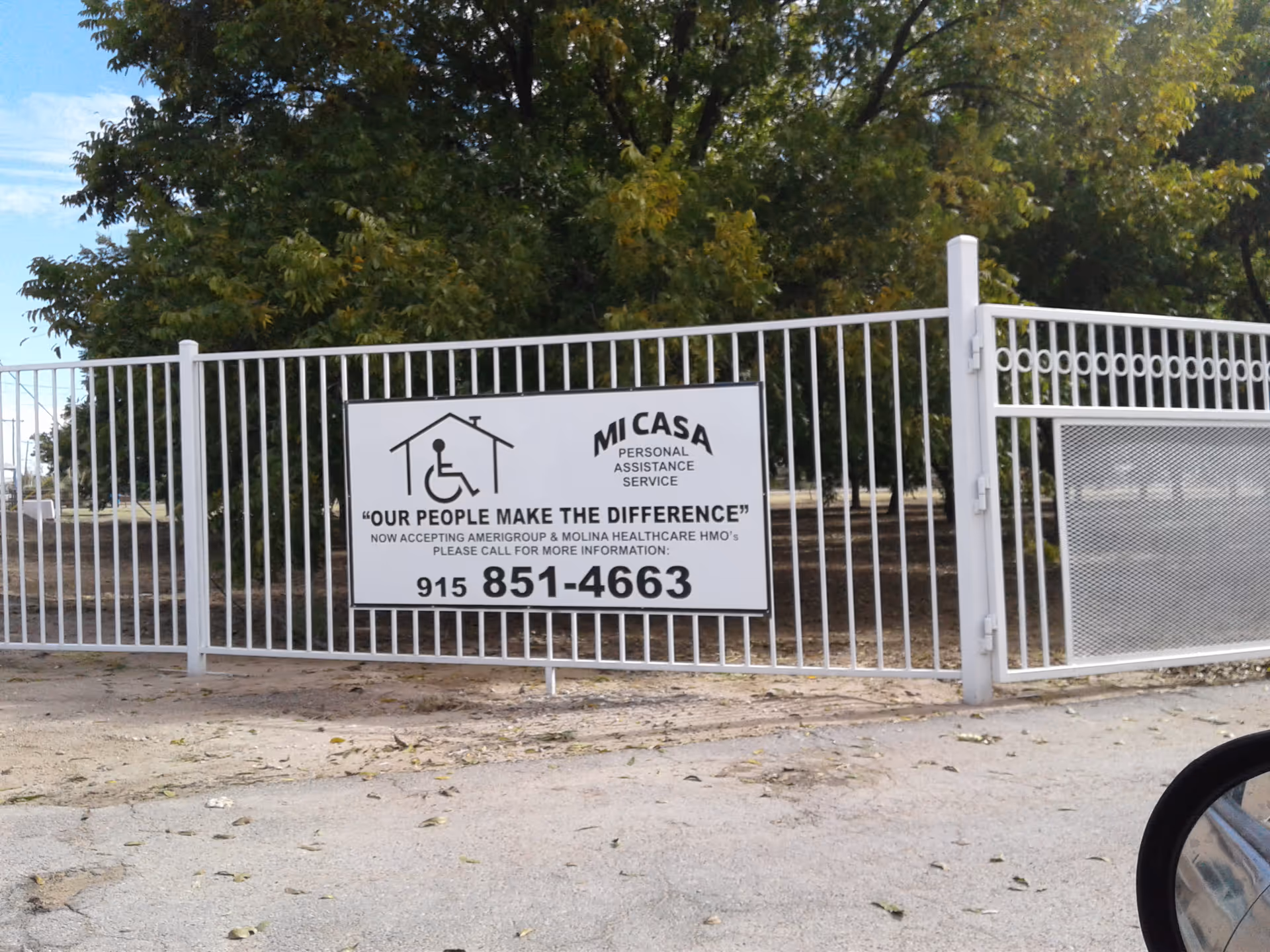 Gated exterior with a Mi Casa sign and wheelchair icon on a metal fence.