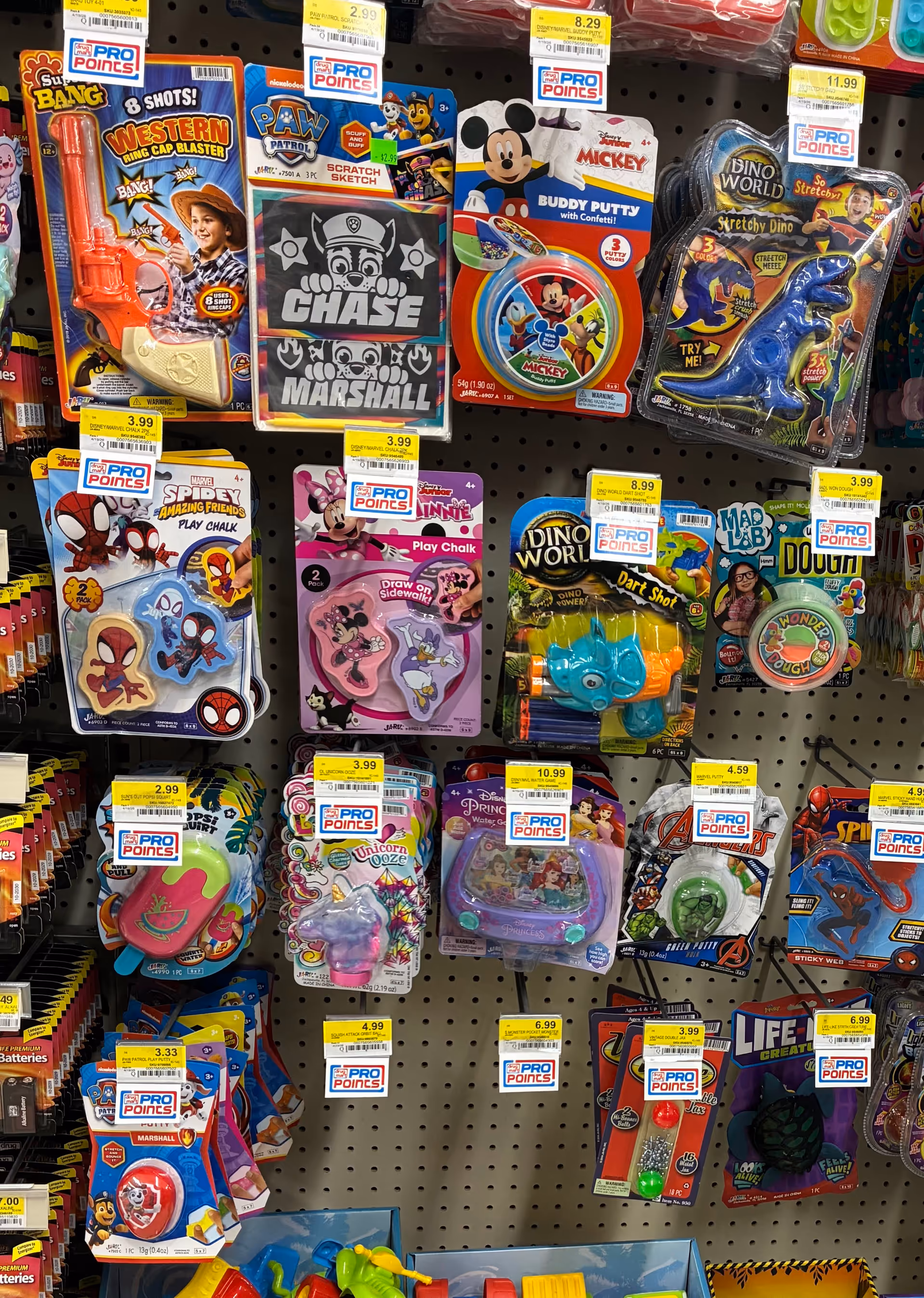 Shelf of colorful toy packs and novelty items displayed on a pegboard.