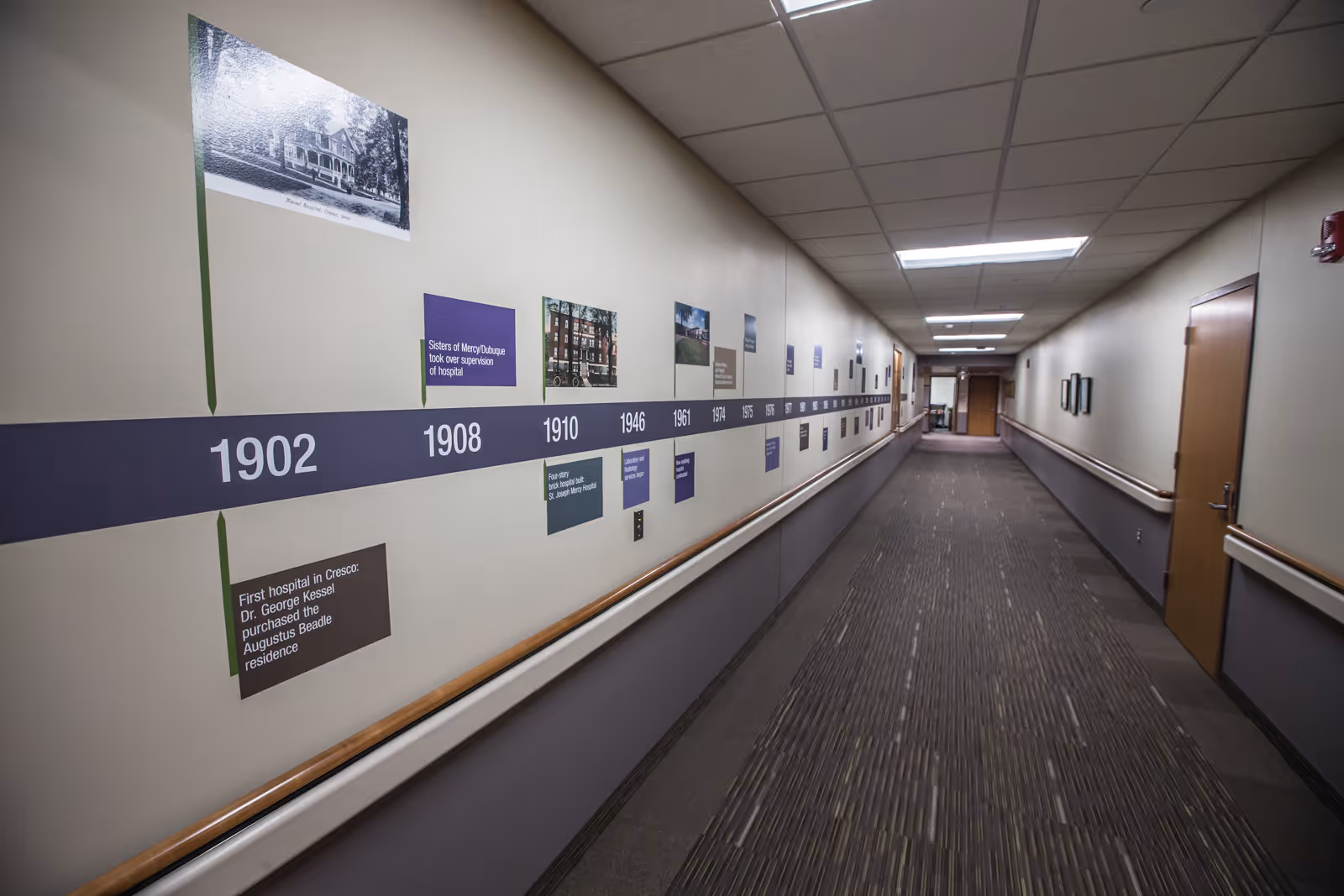 Long interior hallway with a timeline wall displaying years and photos along the corridor.