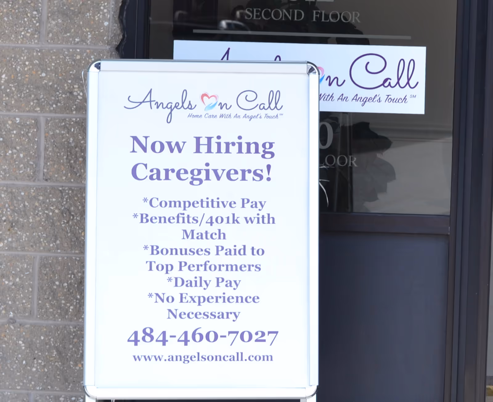 Sign outside Angels On Call Home Care advertising now hiring caregivers at the entrance.