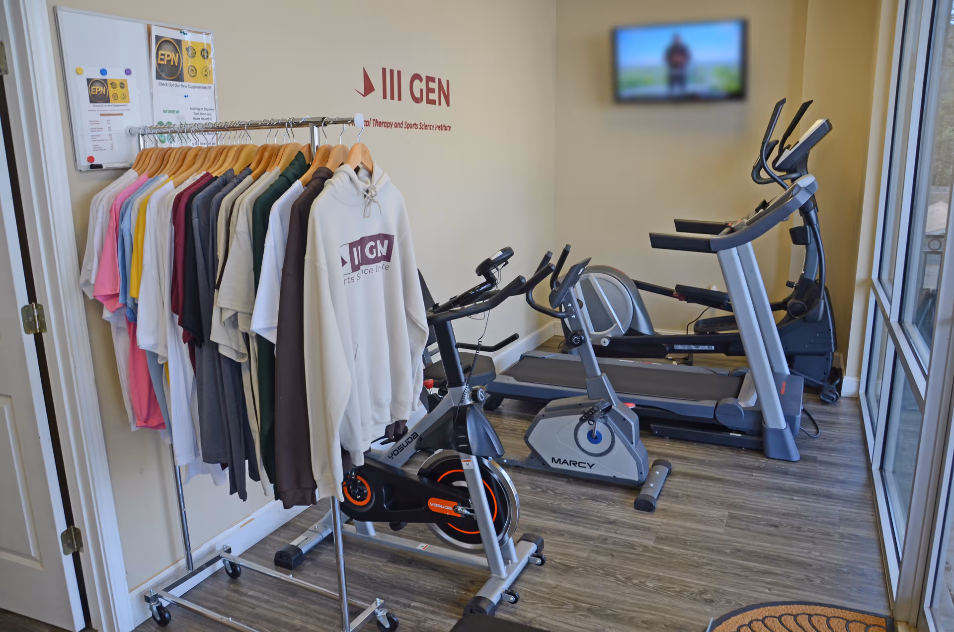 Small indoor fitness area with treadmills, bikes, and a clothing rack.