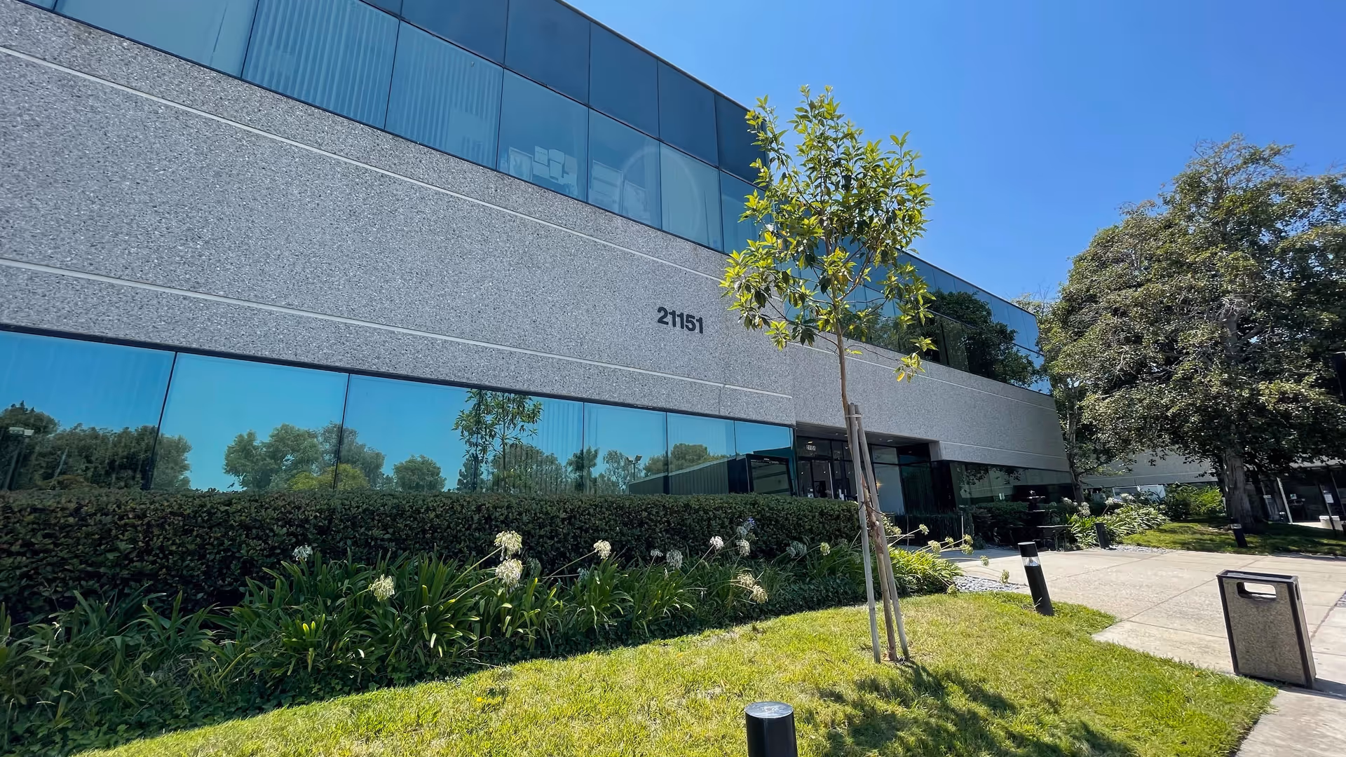 Exterior view of Justin Villa Care, LLC facility with glass-fronted building and landscaping.
