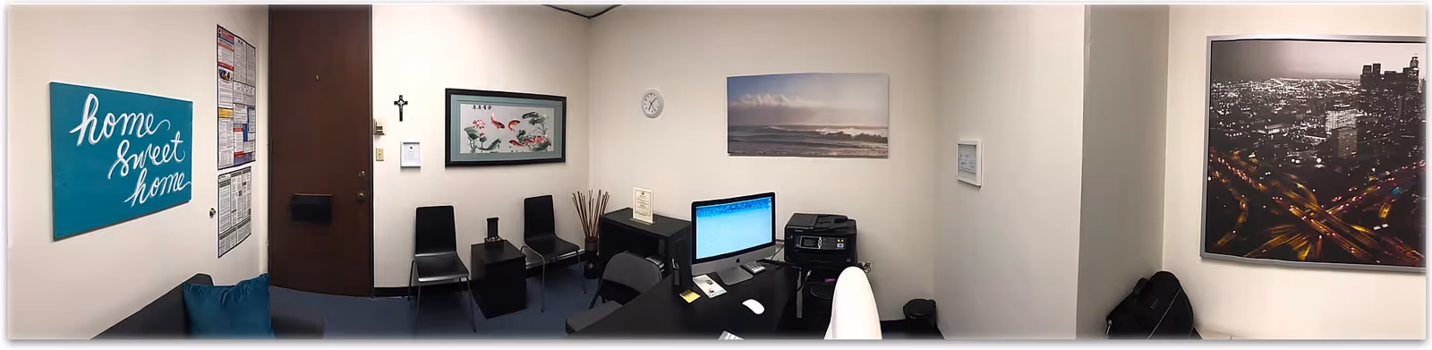 Reception area inside a senior living facility with chairs, desk, computer, and 'home sweet home' sign.