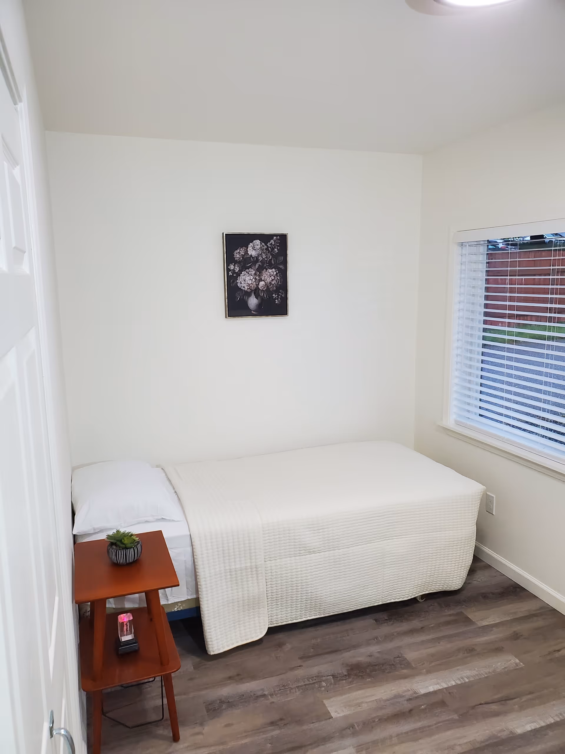 Compact bedroom at JJ Happy Adult Family Home with single bed and nightstand.