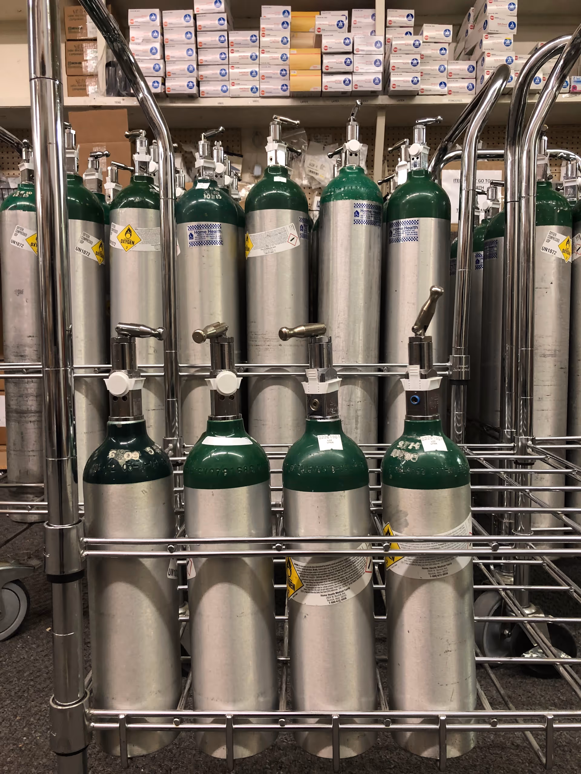 Industrial storage area with medical gas cylinders organized on stainless steel shelving.