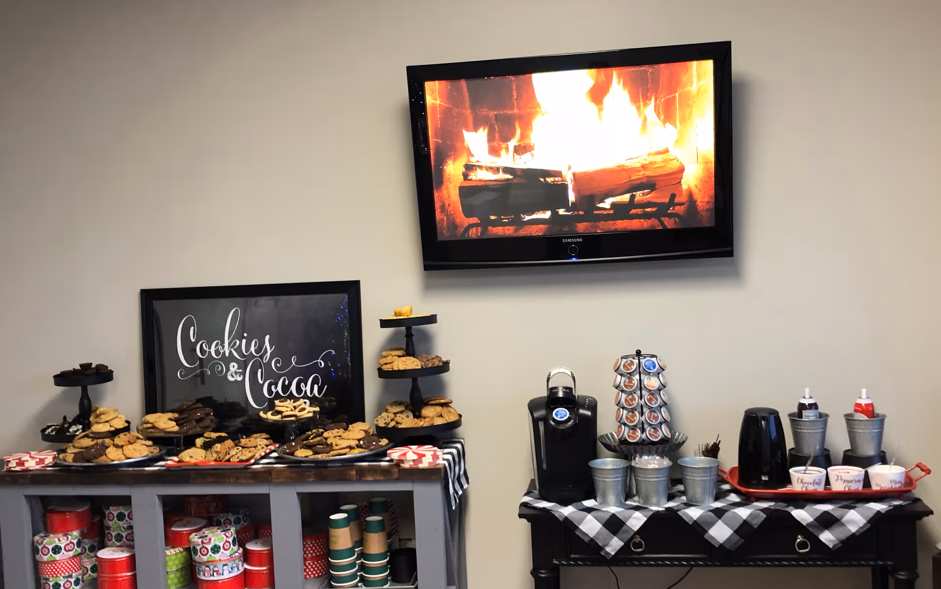 Indoor lounge area with Cookies and Cocoa display, coffee station, and a fireplace TV.