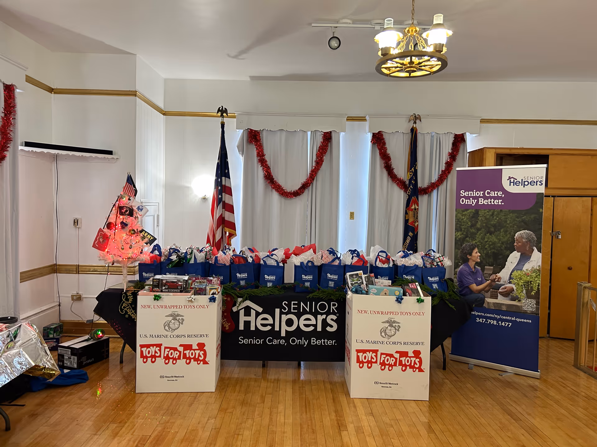 Indoor charity event setup with Senior Helpers banners and gift bags.