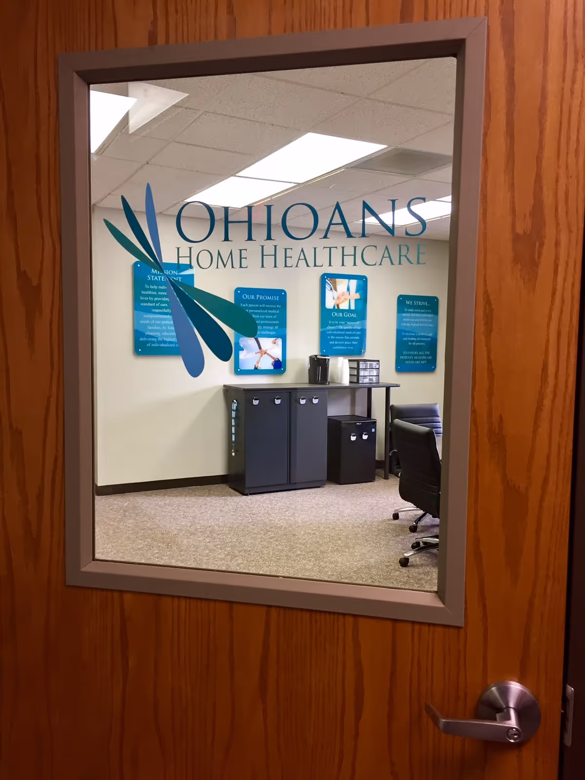 Interior office space with reception desk and Ohioans Home Healthcare signage on wall.