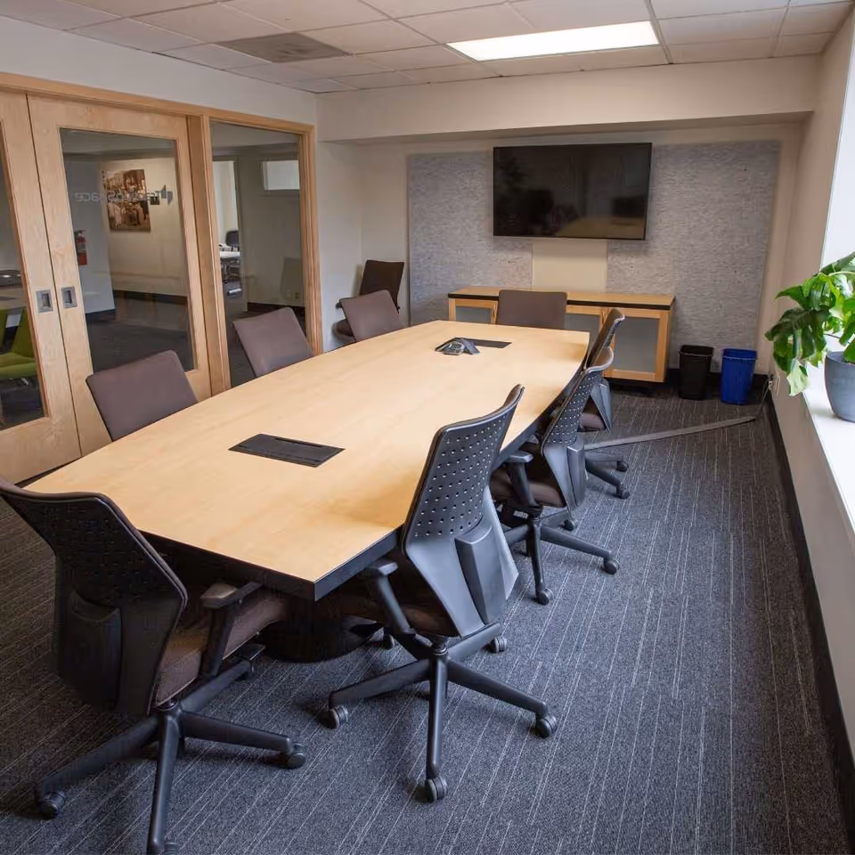 A long conference table with chairs in a modern meeting room.