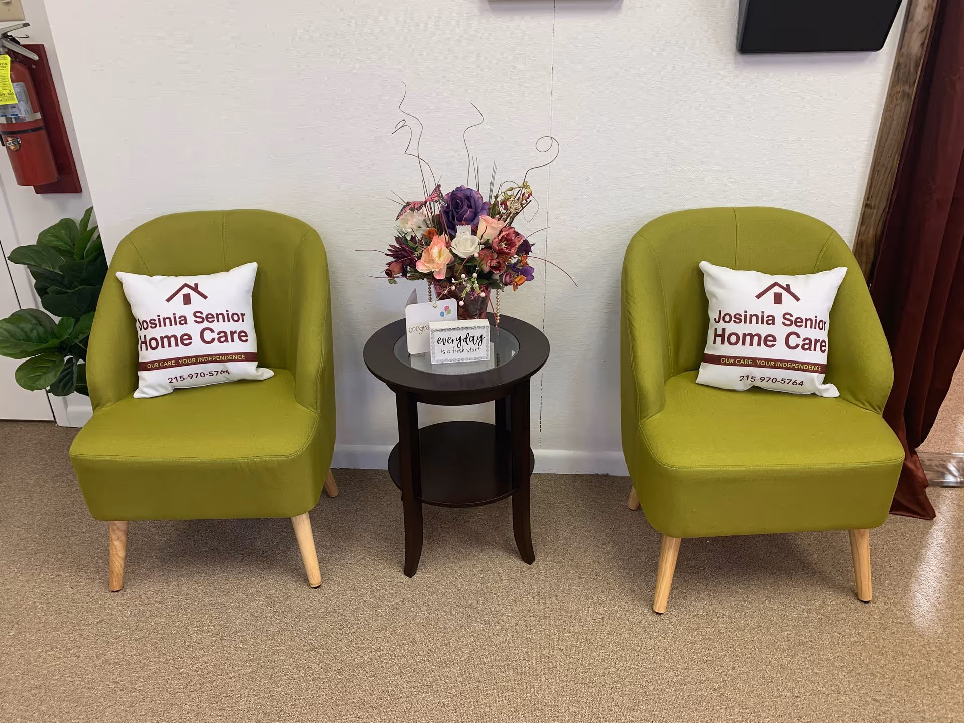 Two lime-green chairs with Josinia Senior Home Care pillows flank a small table.