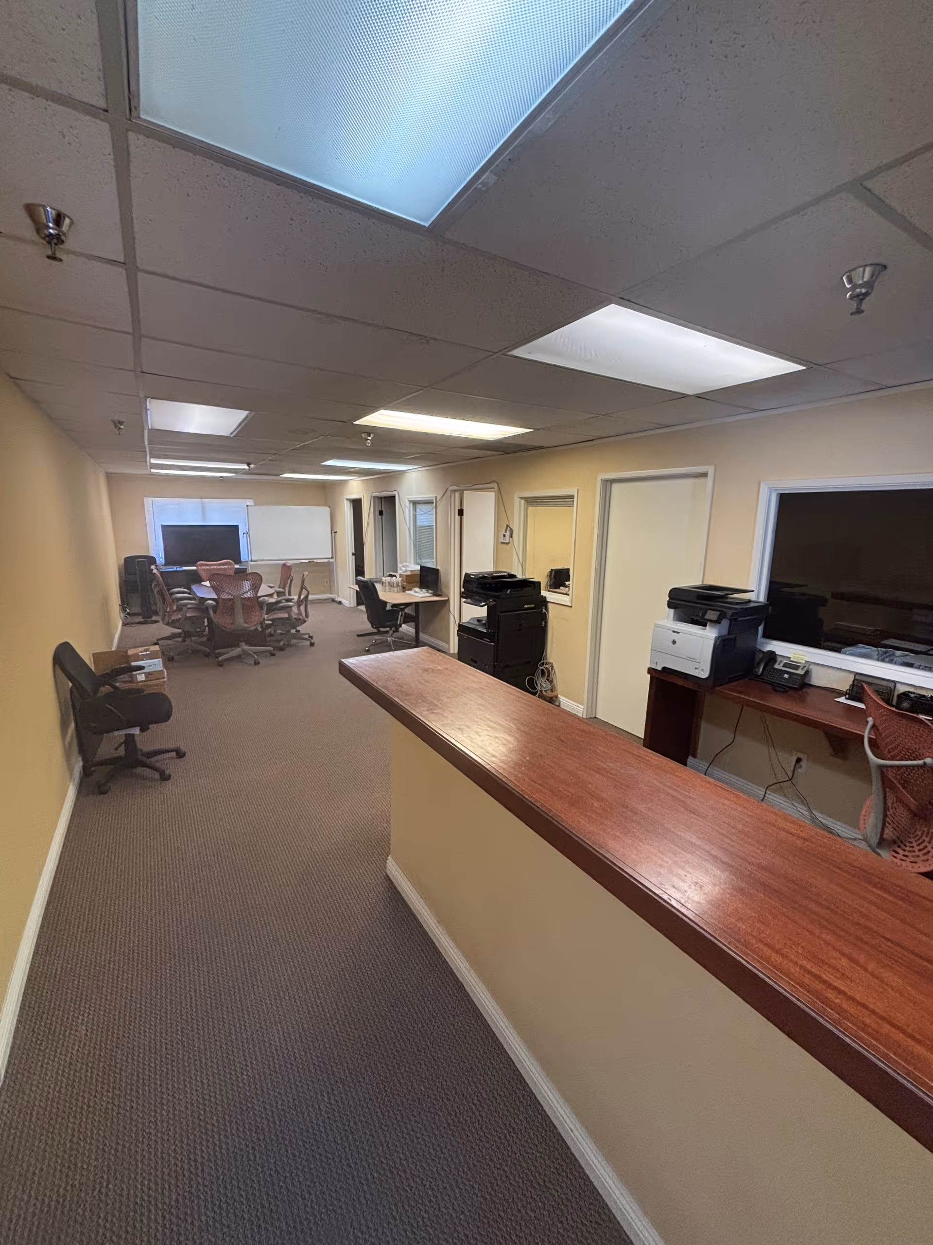Interior corridor of a senior care facility featuring a wooden reception counter and office equipment.