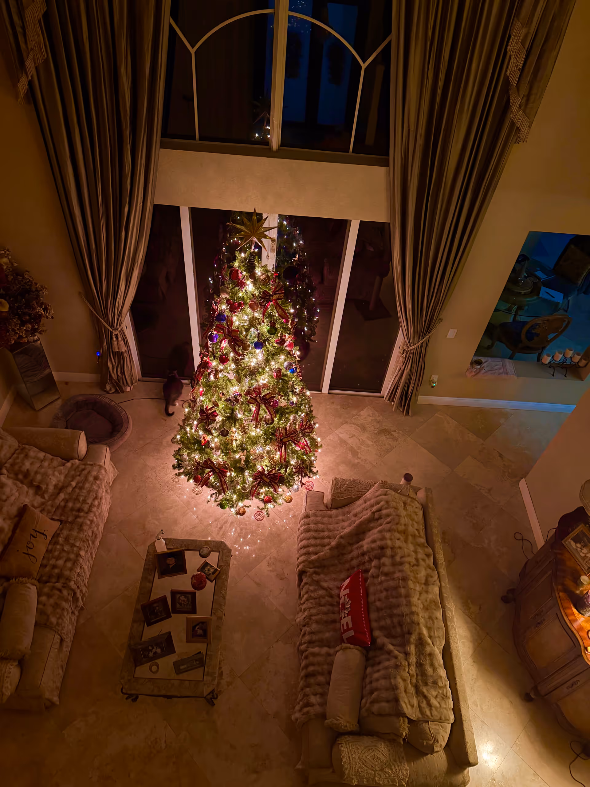 Overhead view of a warmly lit living room with a decorated Christmas tree.