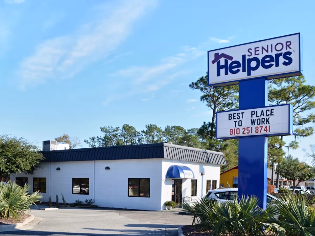 Exterior view of a Senior Helpers facility with a tall sign and white building.