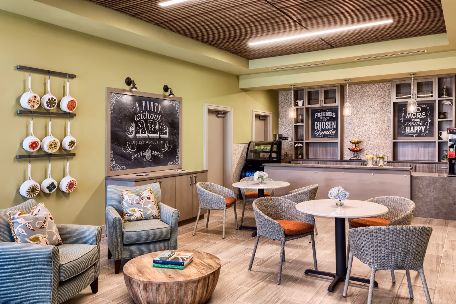 Cozy lounge with round tables, wicker chairs, chalkboards, and a service counter.