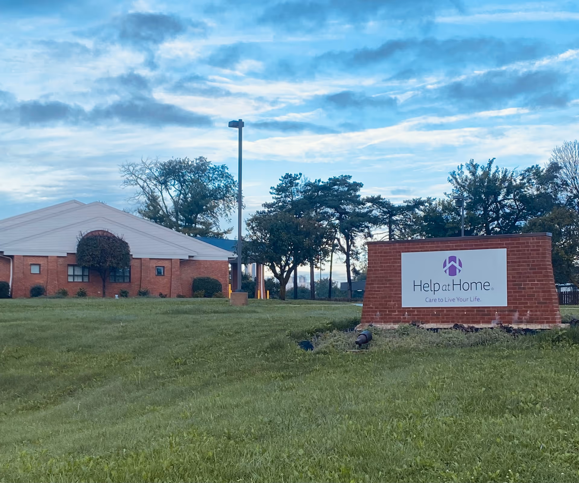 Exterior view of a brick building with a Help at Home sign.