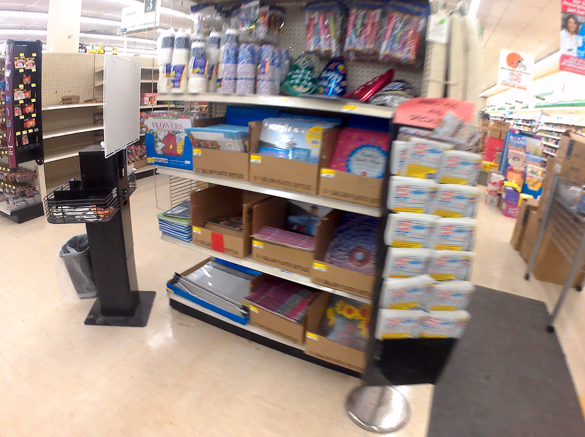 Inside Discount Drug Mart, shelves stocked with boxes and assorted merchandise in an aisle.