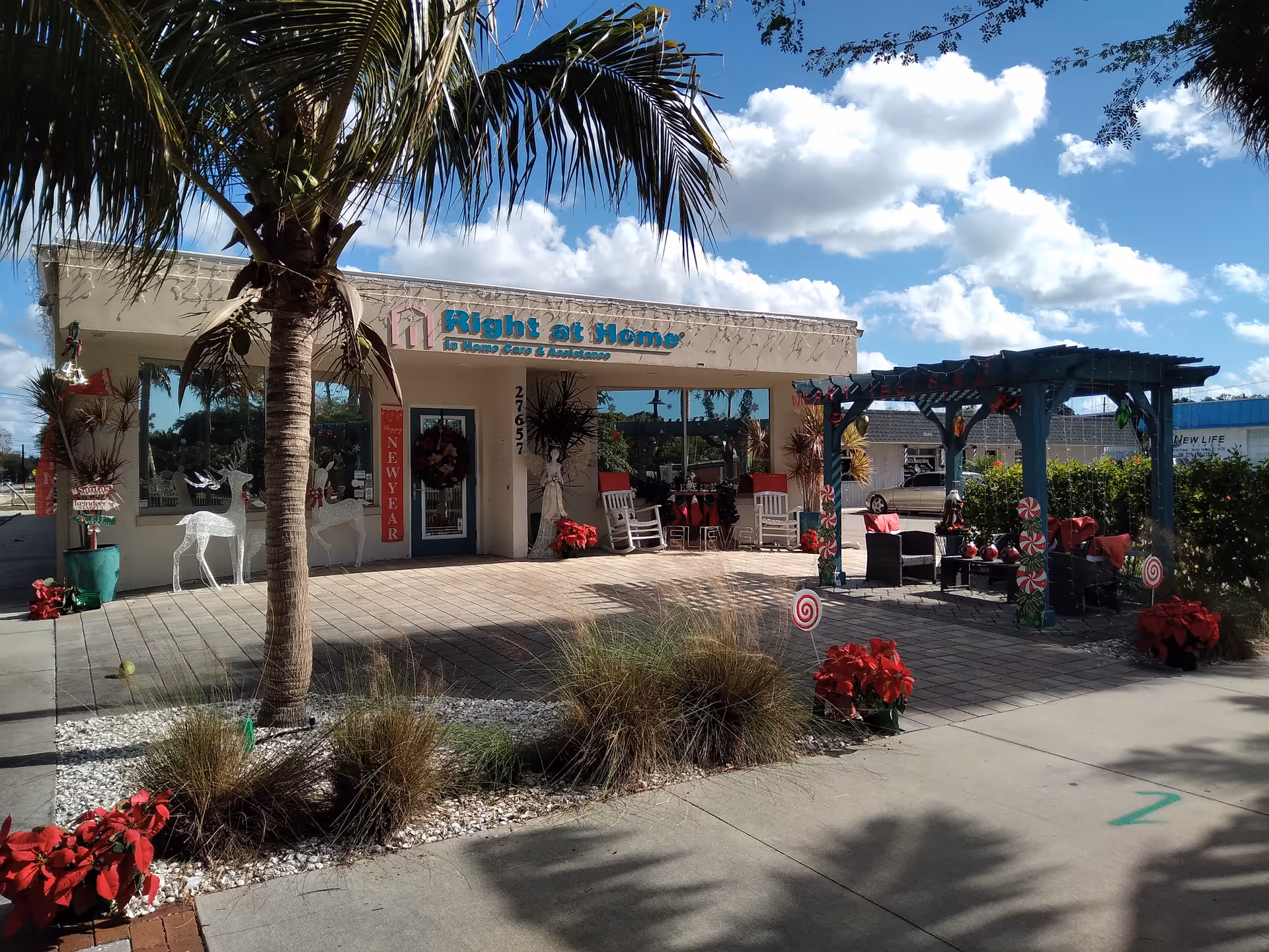Front view of Right at Home senior living exterior with plants and outdoor seating.