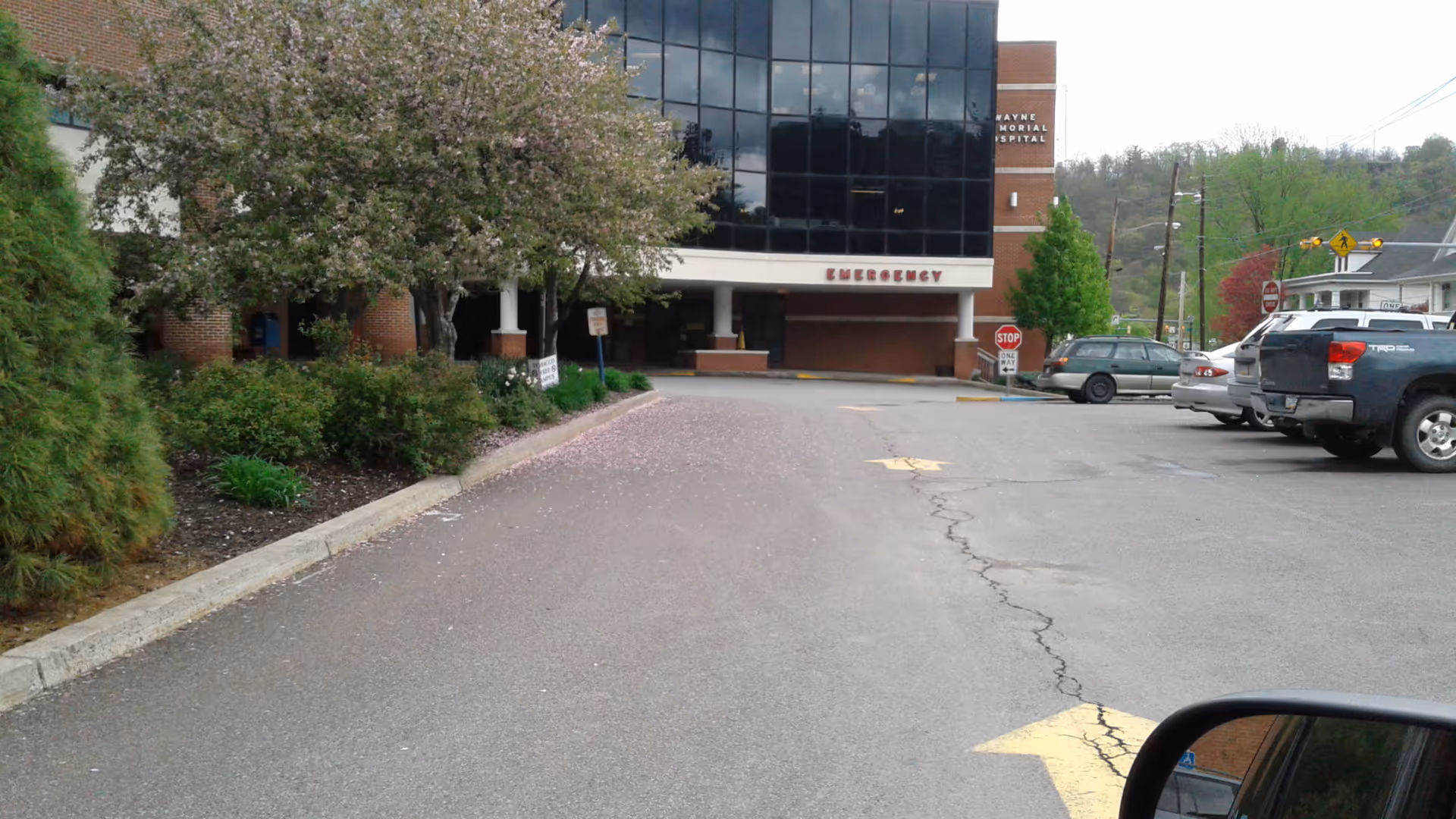 Exterior view of Wayne Memorial Hospital with emergency entrance and parking lot.