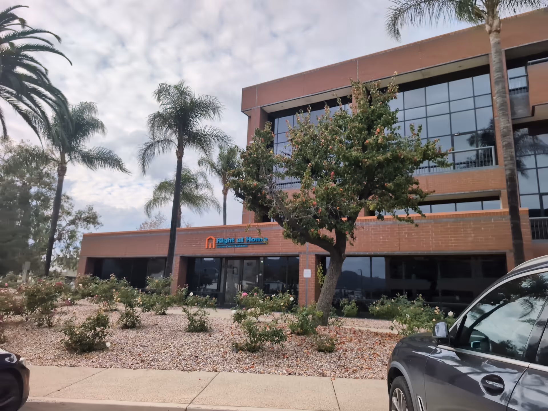 Exterior view of a Right at Home senior facility with brick facade and landscaping.