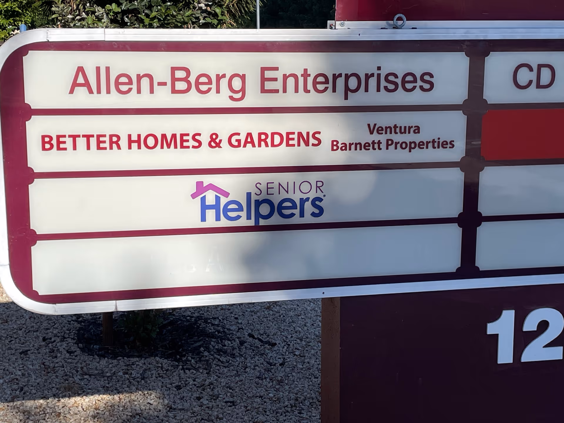 Outdoor signboard listing Senior Helpers, Allen-Berg Enterprises, and Better Homes & Gardens.