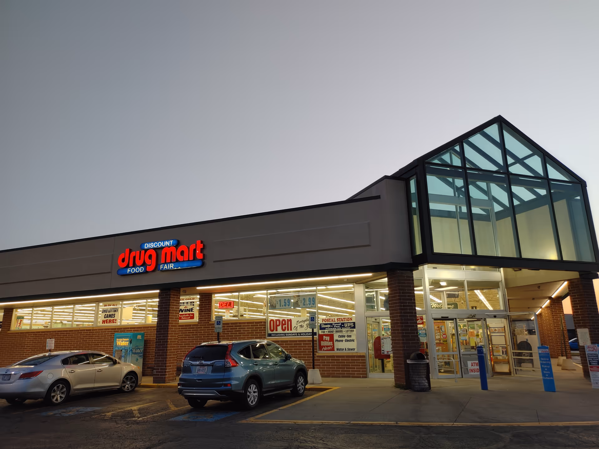 Exterior view of a Discount Drug Mart storefront with brick facade and glass entrance.