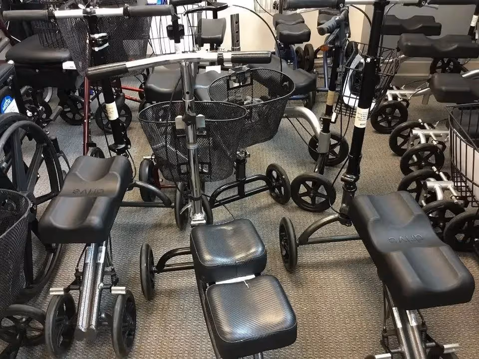 Indoor storage area filled with mobility scooters and walkers.
