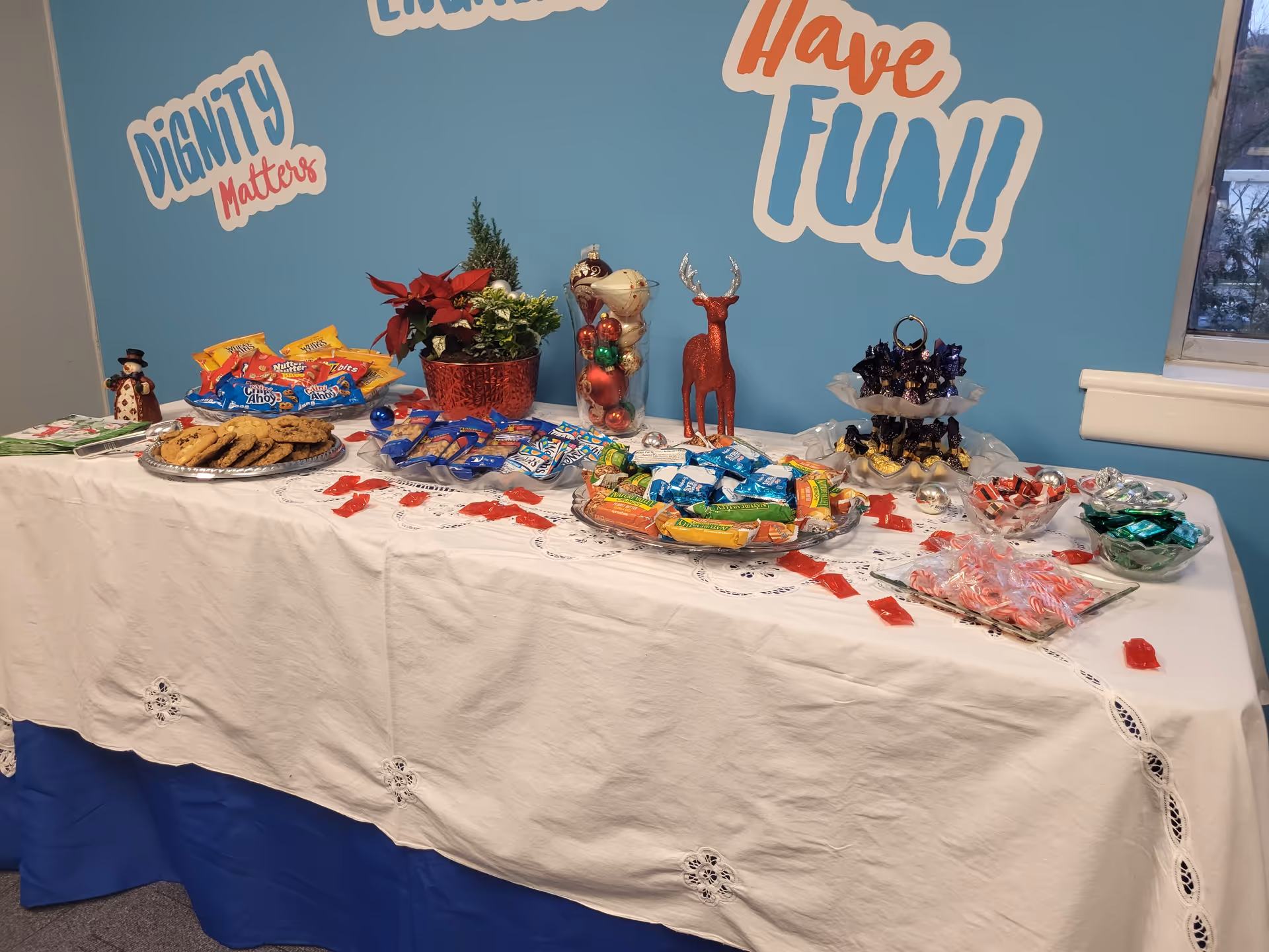 Snack table with cookies and candy in a blue-walled indoor room.