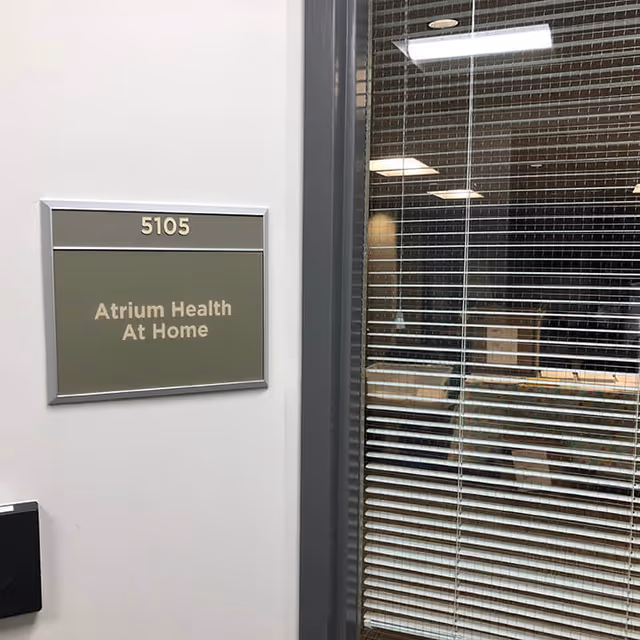 Indoor doorway with room 5105 and Atrium Health At Home sign.