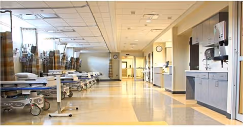 Long interior corridor with hospital beds and medical equipment along both sides.