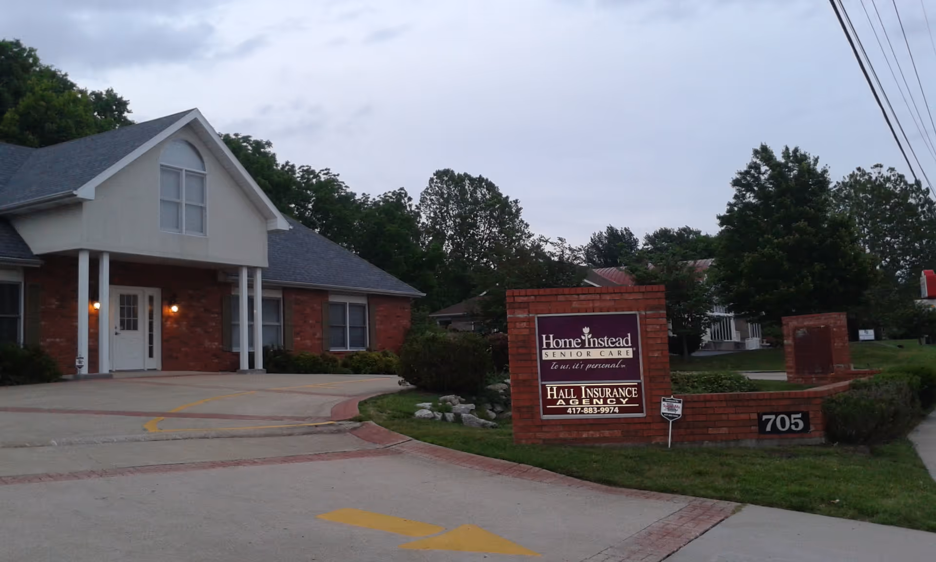 Exterior view of a brick senior care facility with a Home Instead sign.