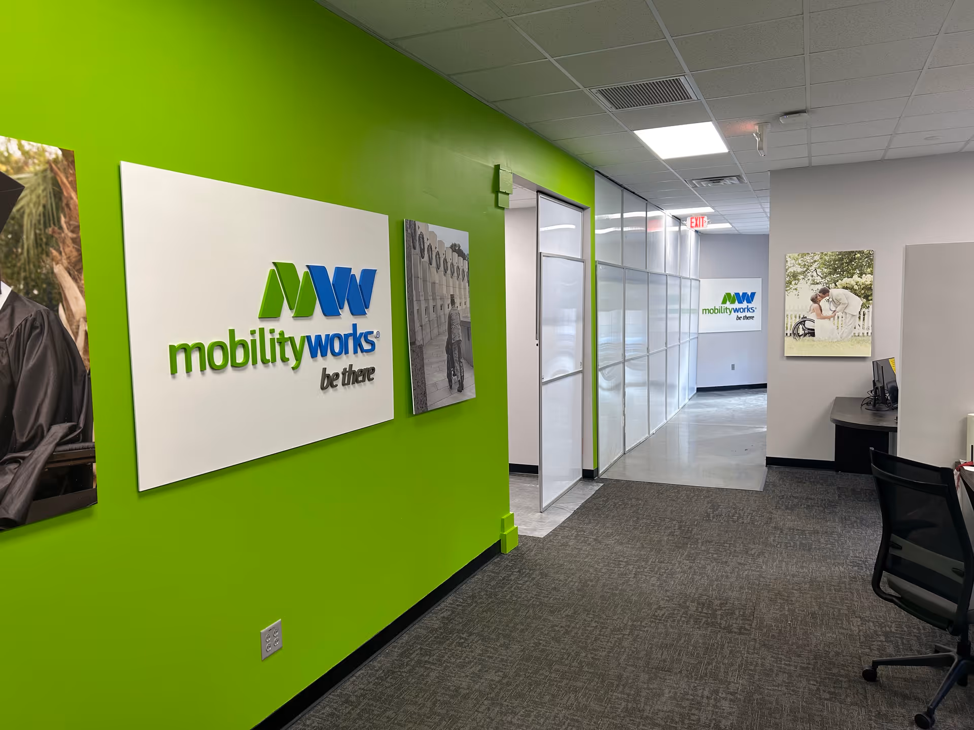 Bright lime-green hallway with MobilityWorks signage and glass-walled offices.