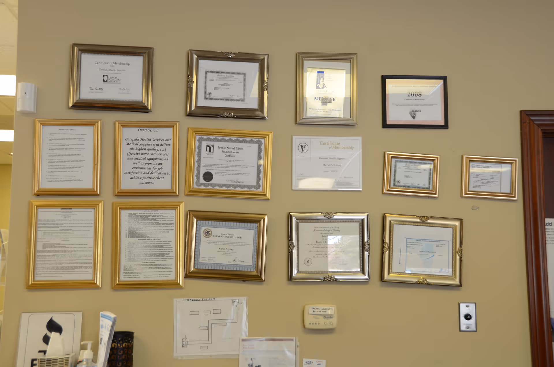 Interior wall displaying many framed certificates and documents.