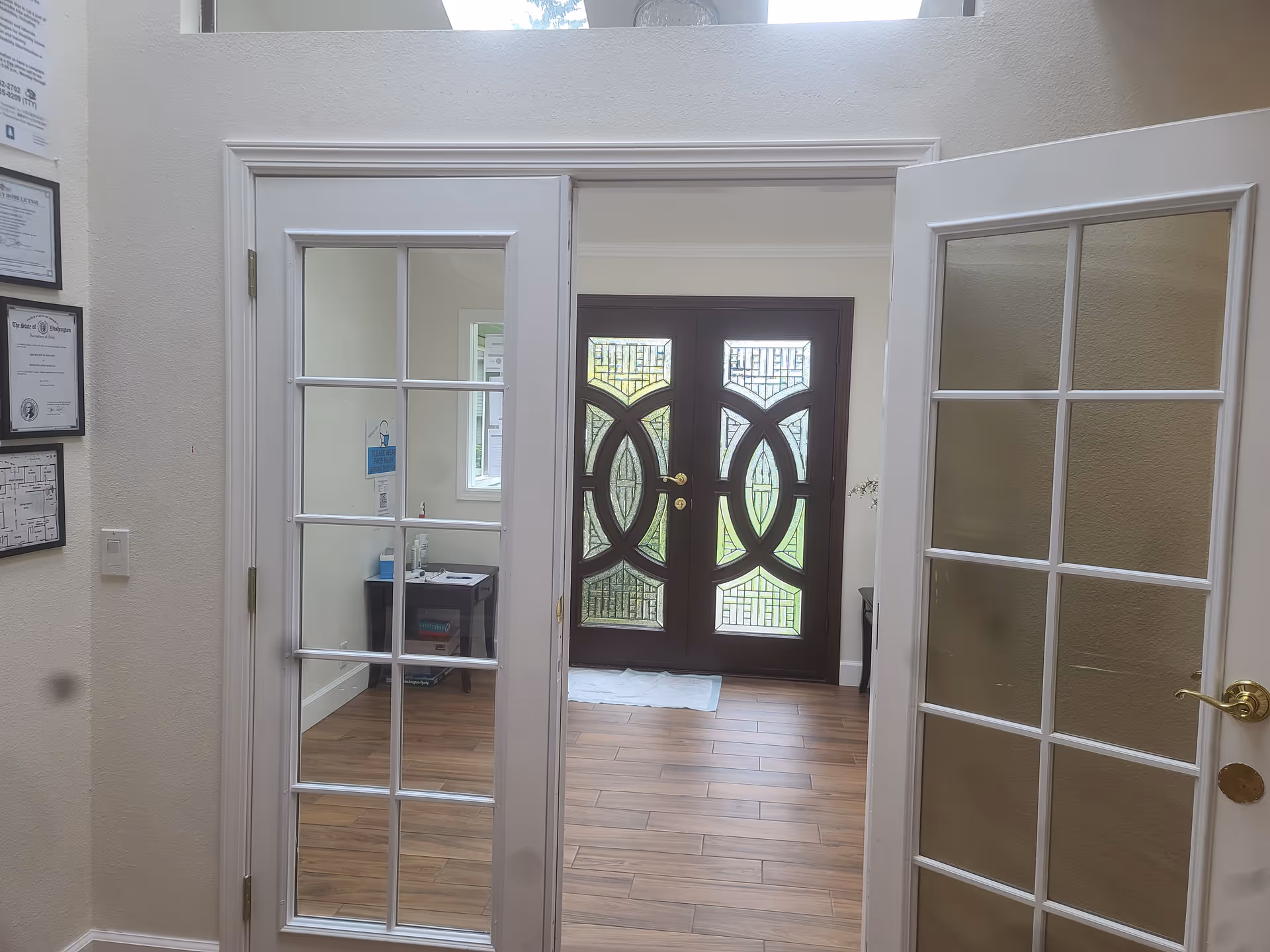Interior entryway with glass-pane French doors and decorative double doors at the far entrance.