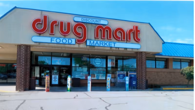 Exterior view of a Discount Drug Mart storefront with brick columns and a large sign.