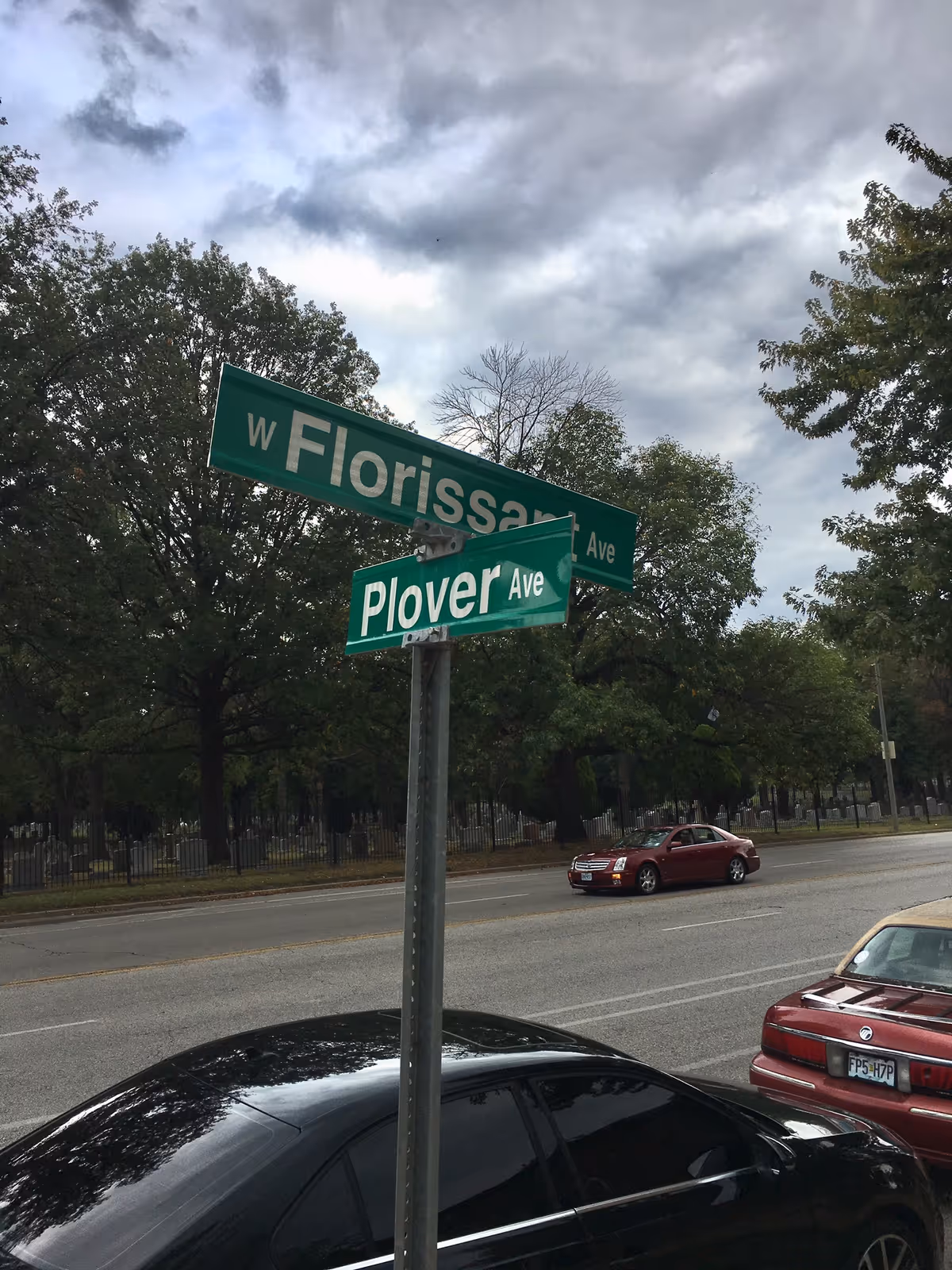 Street intersection with green signs reading Florissant Ave and Plover Ave.