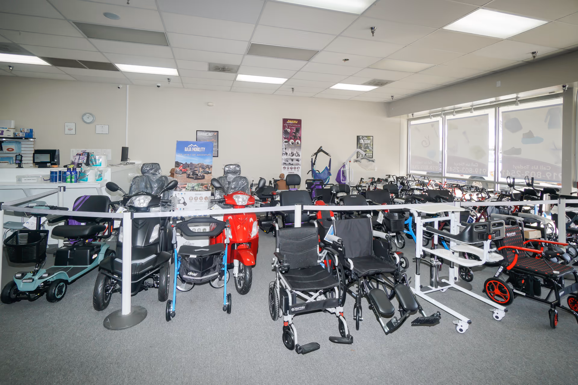 Interior showroom with numerous mobility aids including wheelchairs, scooters, and walkers.