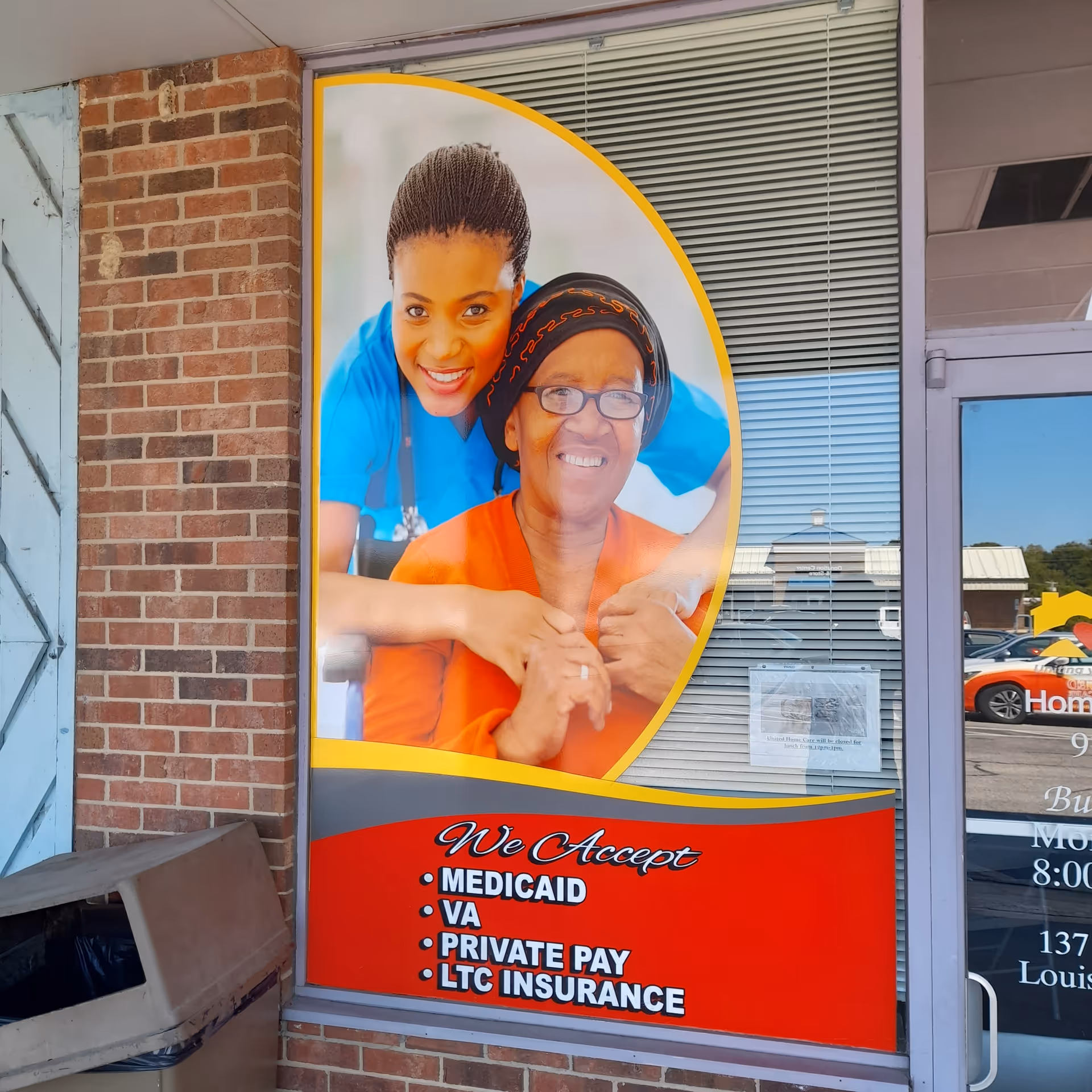 Exterior storefront window with a large poster of a caregiver and an elderly woman.