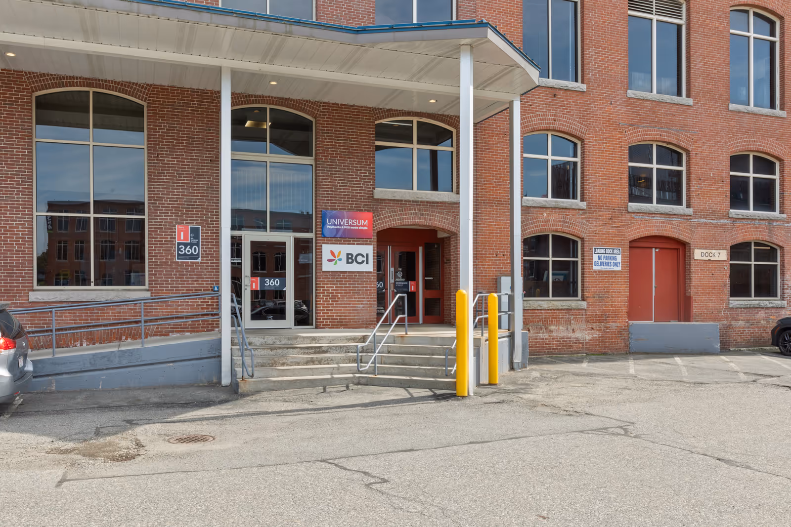 Brick building exterior with BCI entrance, glass doors, and parking lot.