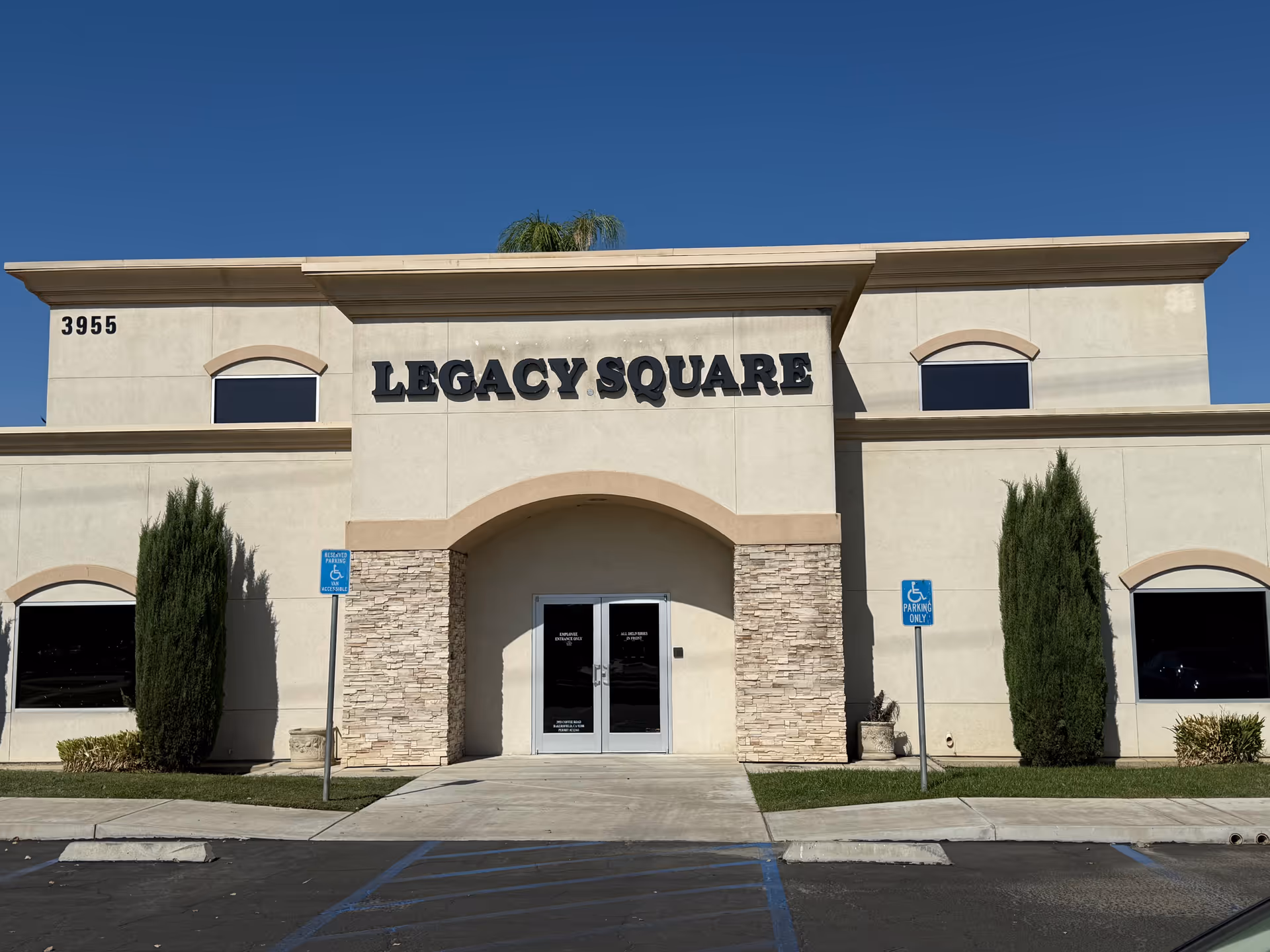 Facade of Legacy Square building with arched entrance and stone accents.