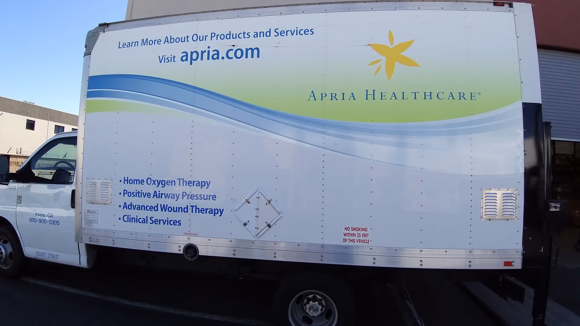 A large white delivery truck with Apria Healthcare branding and blue curved graphics.