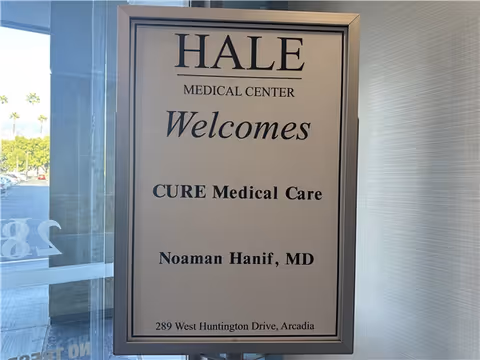 Framed sign inside the facility welcomes CURE Medical Care and physician Noaman Hanif, MD.
