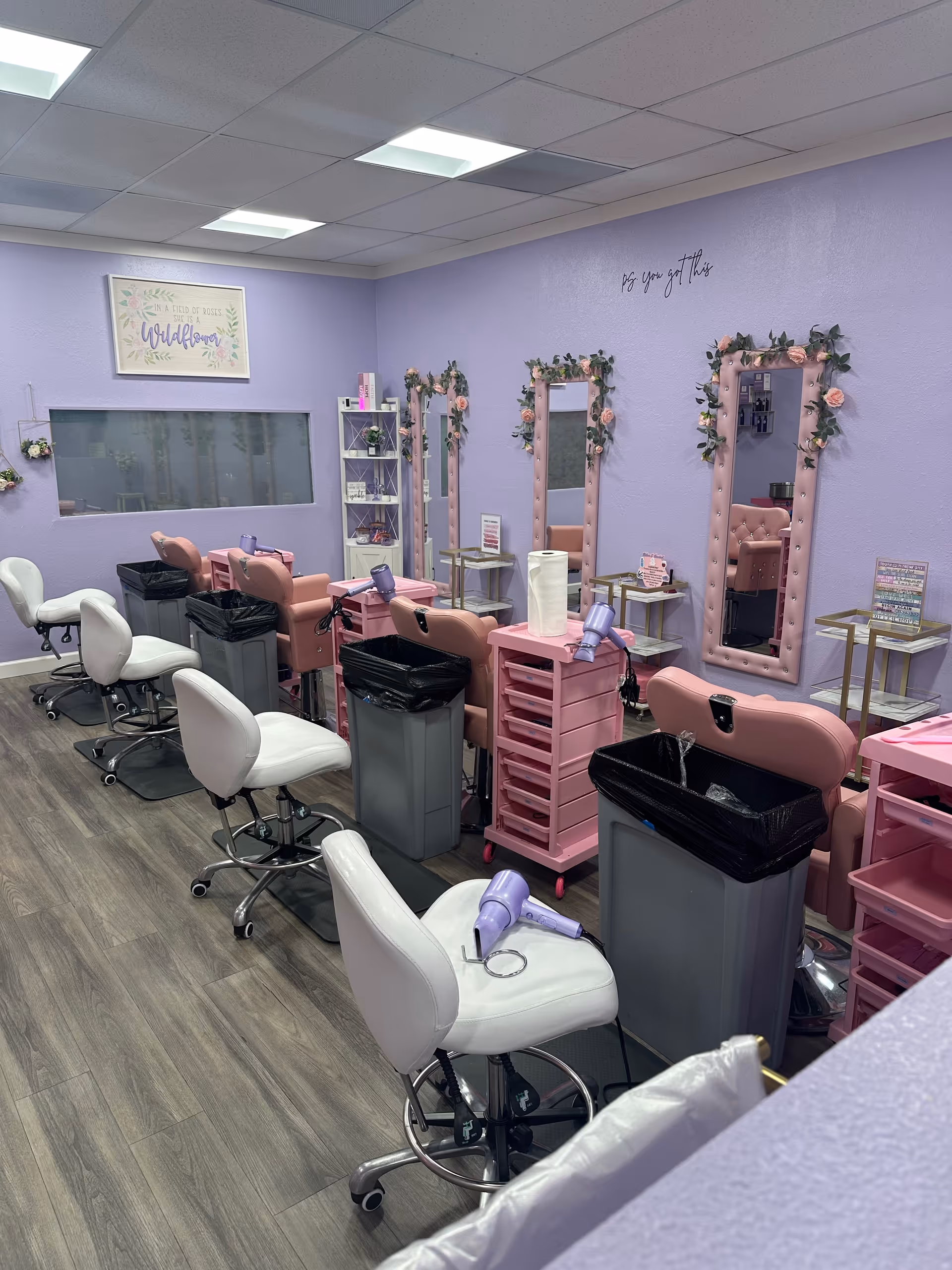 Lavender-walled senior salon with pink styling chairs, mirrors, and floral decor.