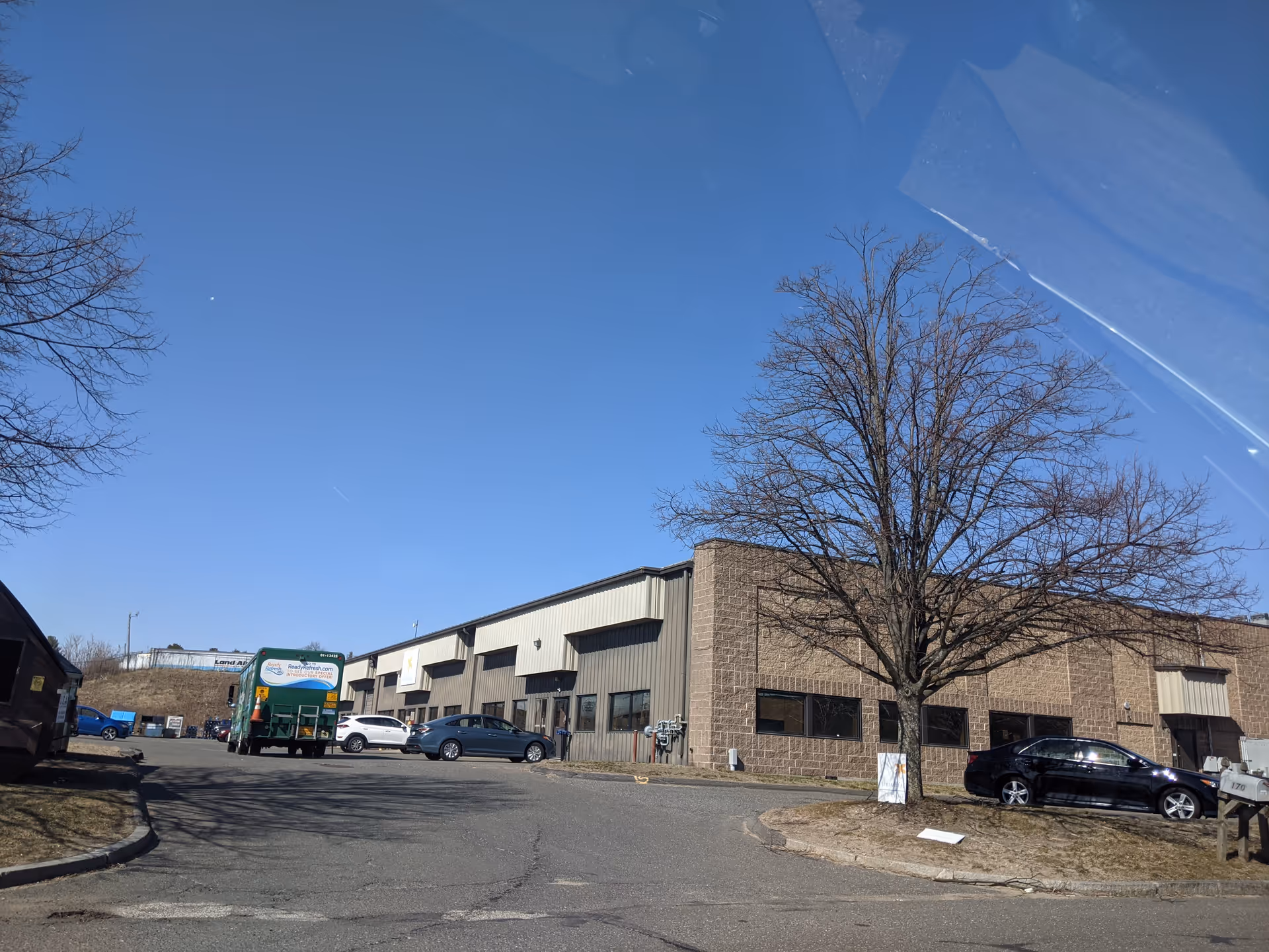 Exterior view of Apria Healthcare facility with parking lot and leafless tree.