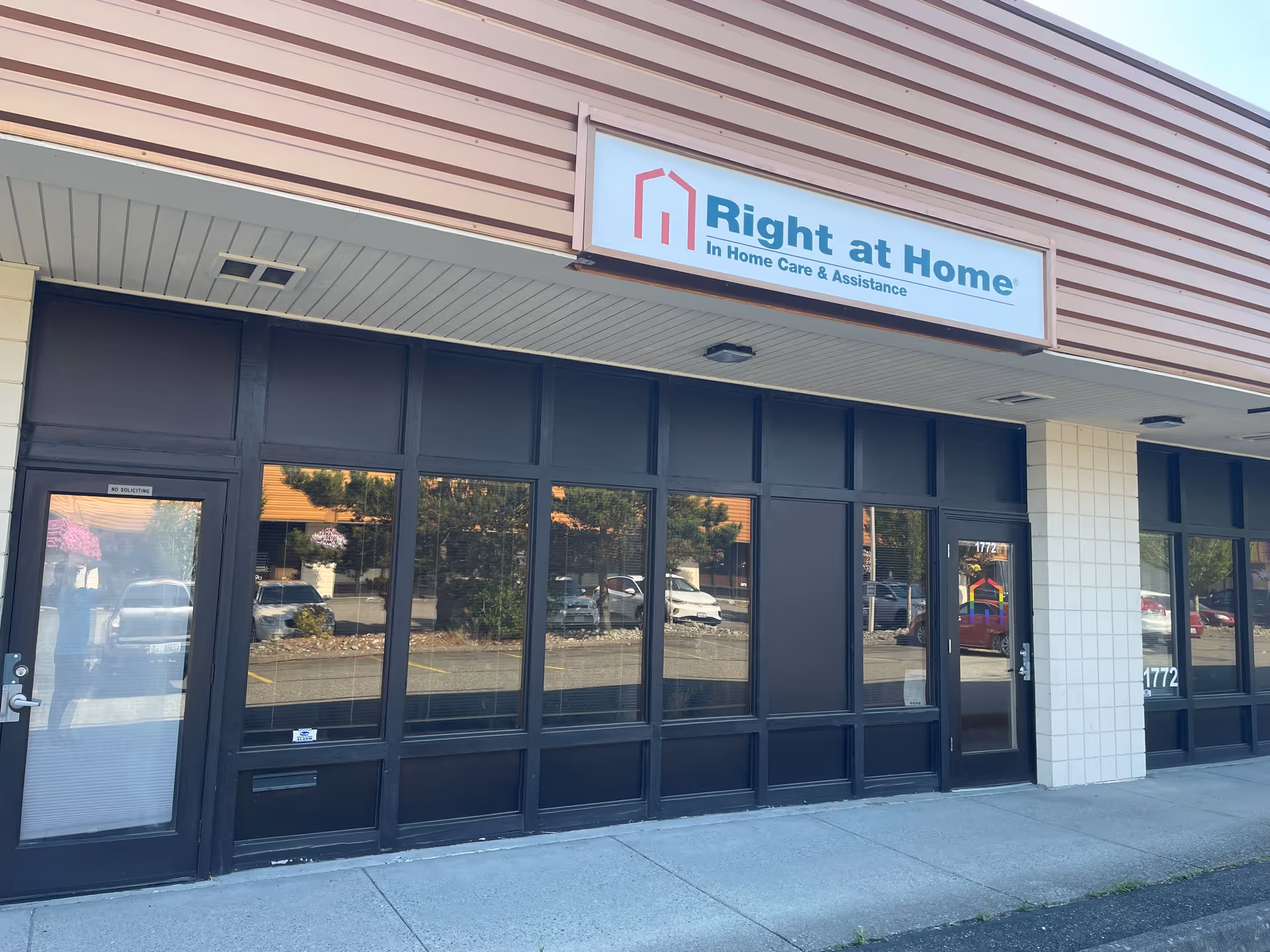 Front exterior of Right at Home storefront with glass windows and a sign.