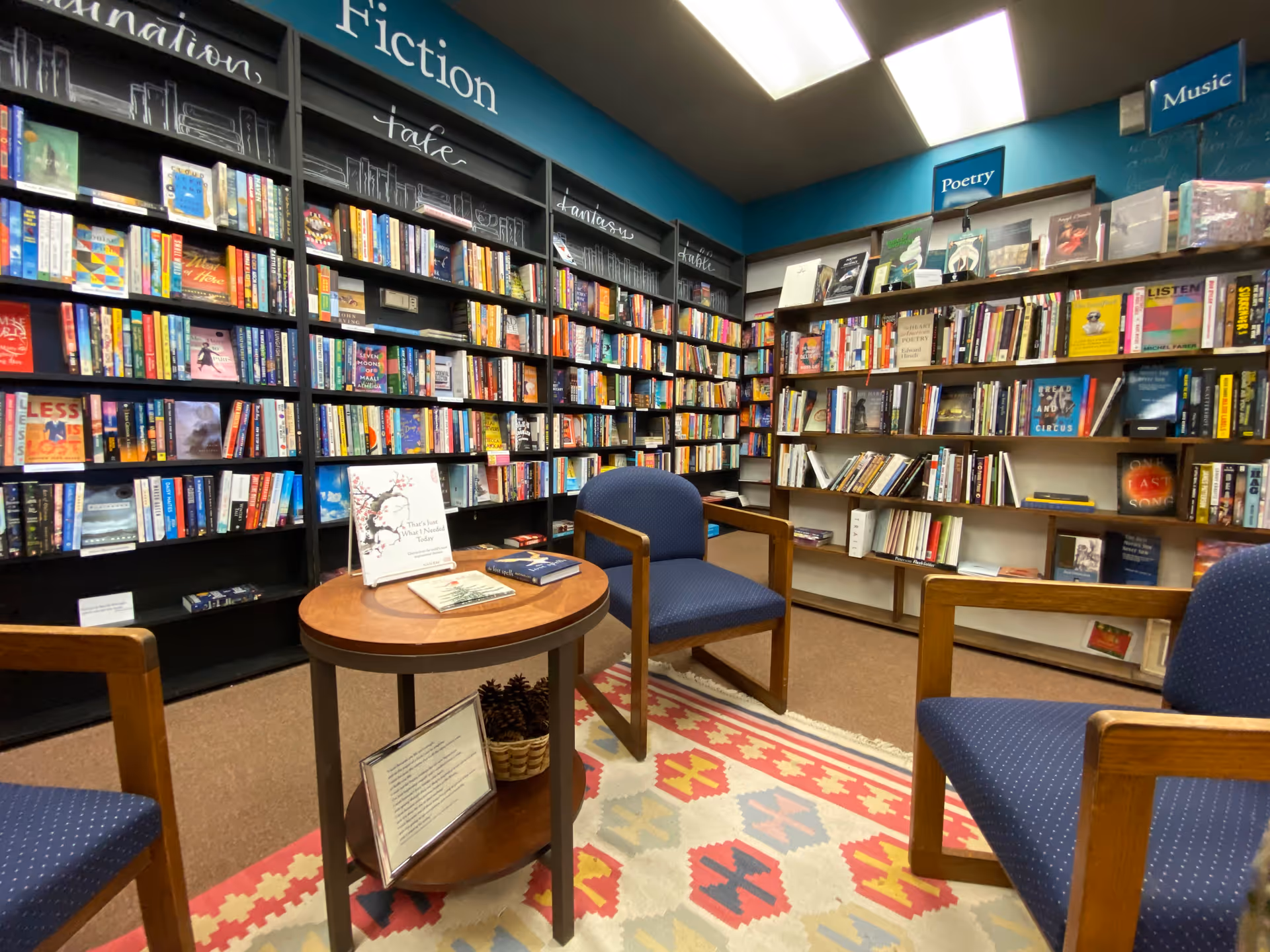 A library seating area inside a senior living facility with bookshelves and chairs.