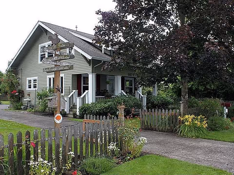 Quaint cottage-style senior care facility with a wooden fence and manicured front garden