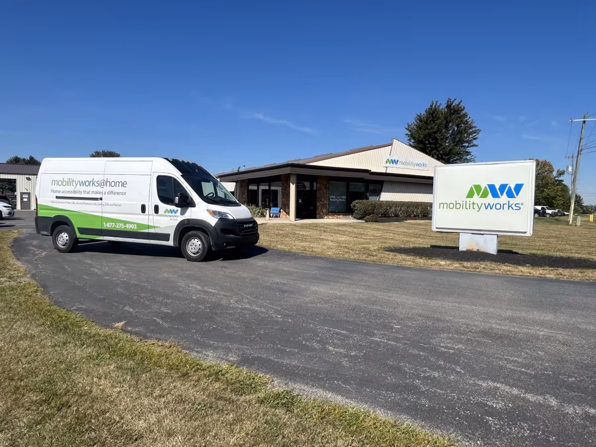 MobilityWorks van parked in front of a beige building with a large sign.